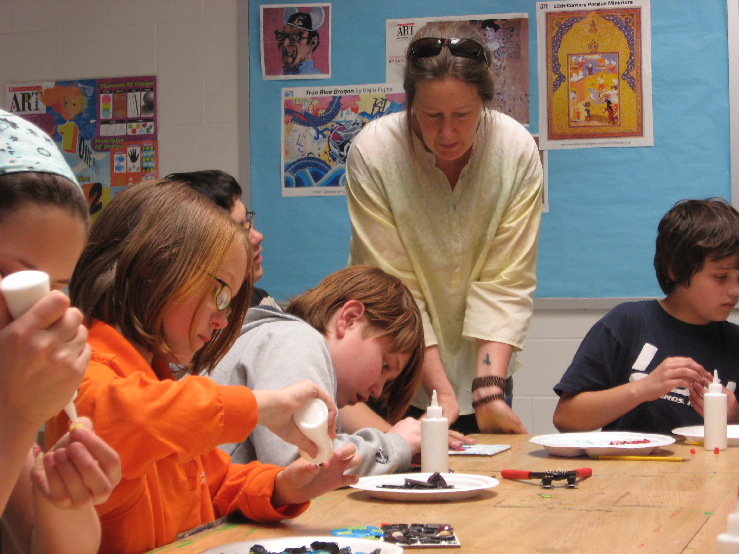 I'm working with young children in this photo, seeing how they are doing fitting and placing mosaic pieces.