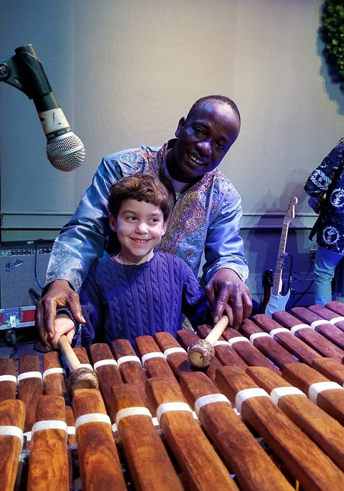 An audience member tries out the balafon.