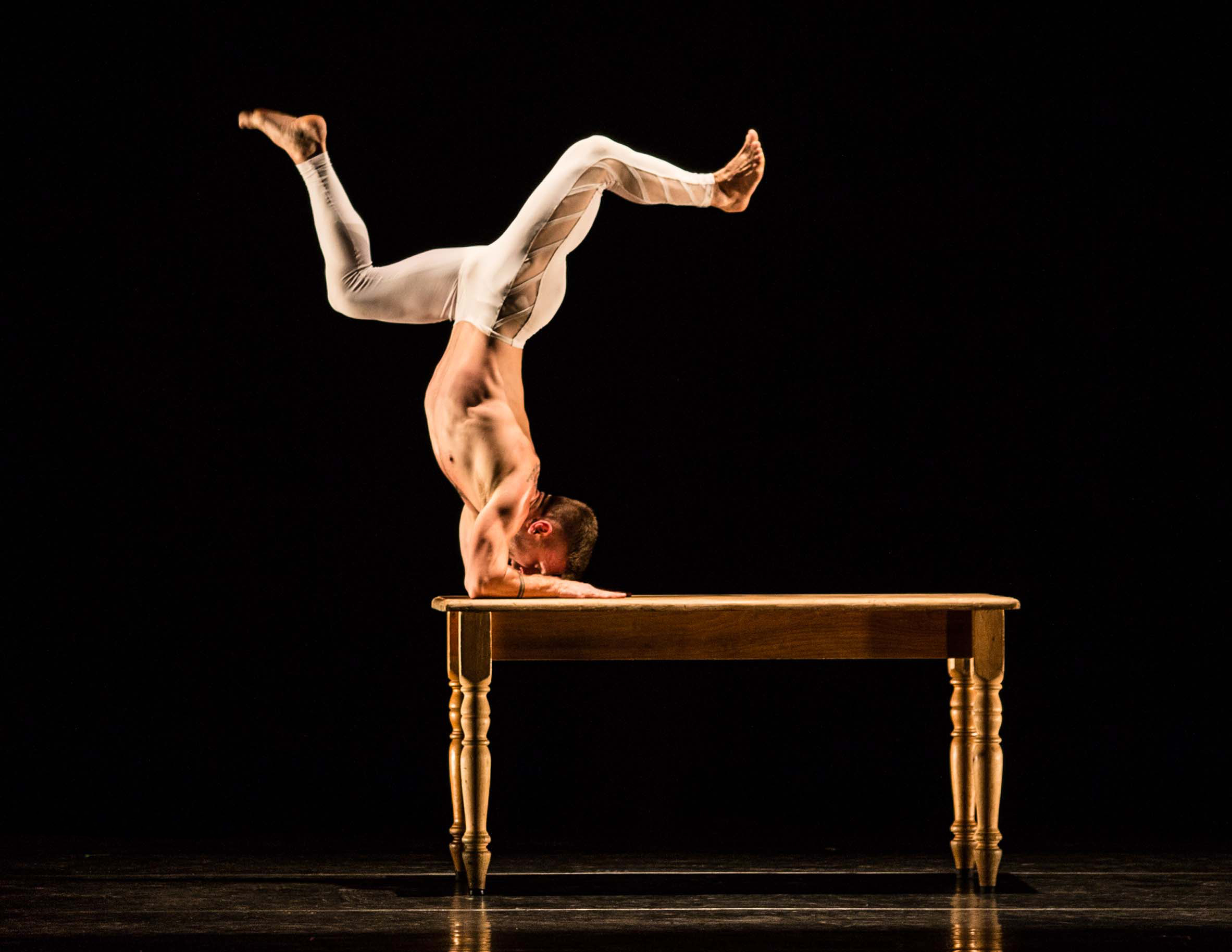 MOMIX Dancer doing a handstand on a table
