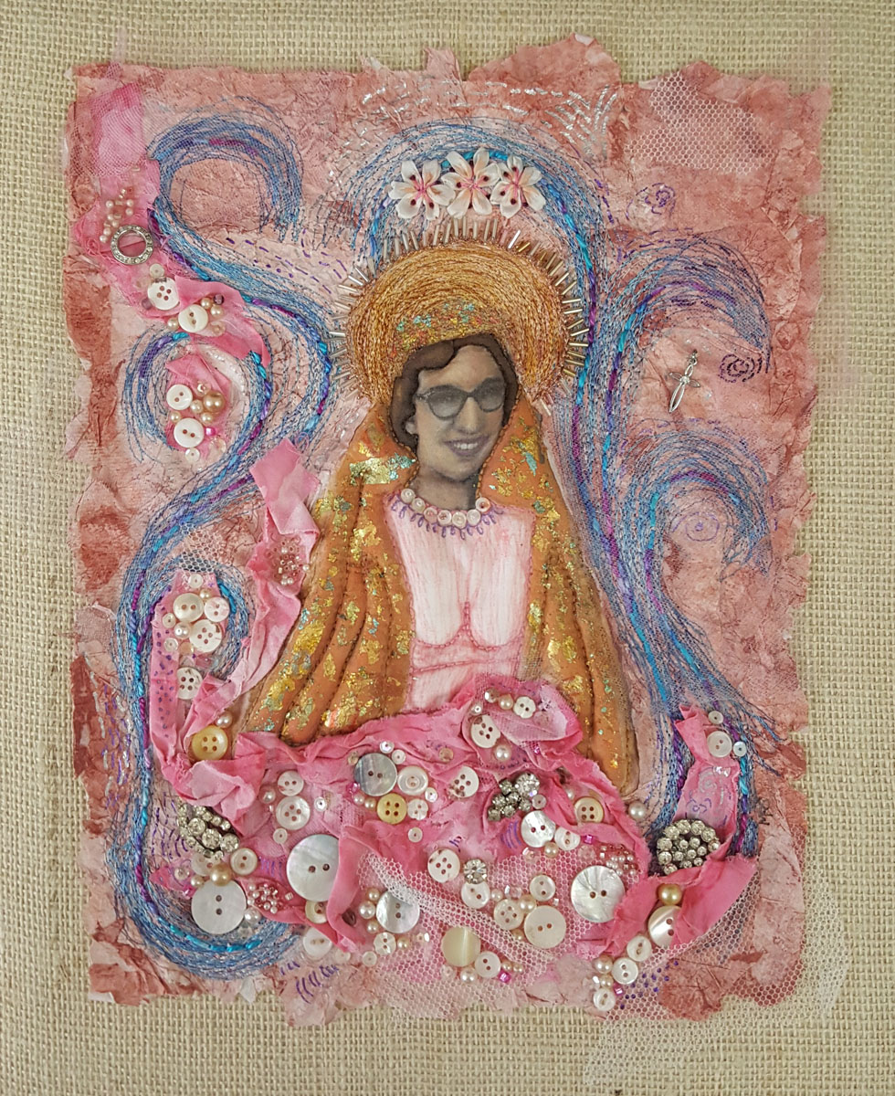 An image of a woman surrounded by swilring embroidery in blues and pinks with beads, crystals and pearl buttons