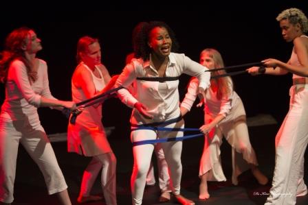 Women in white constrained by fabric ropes