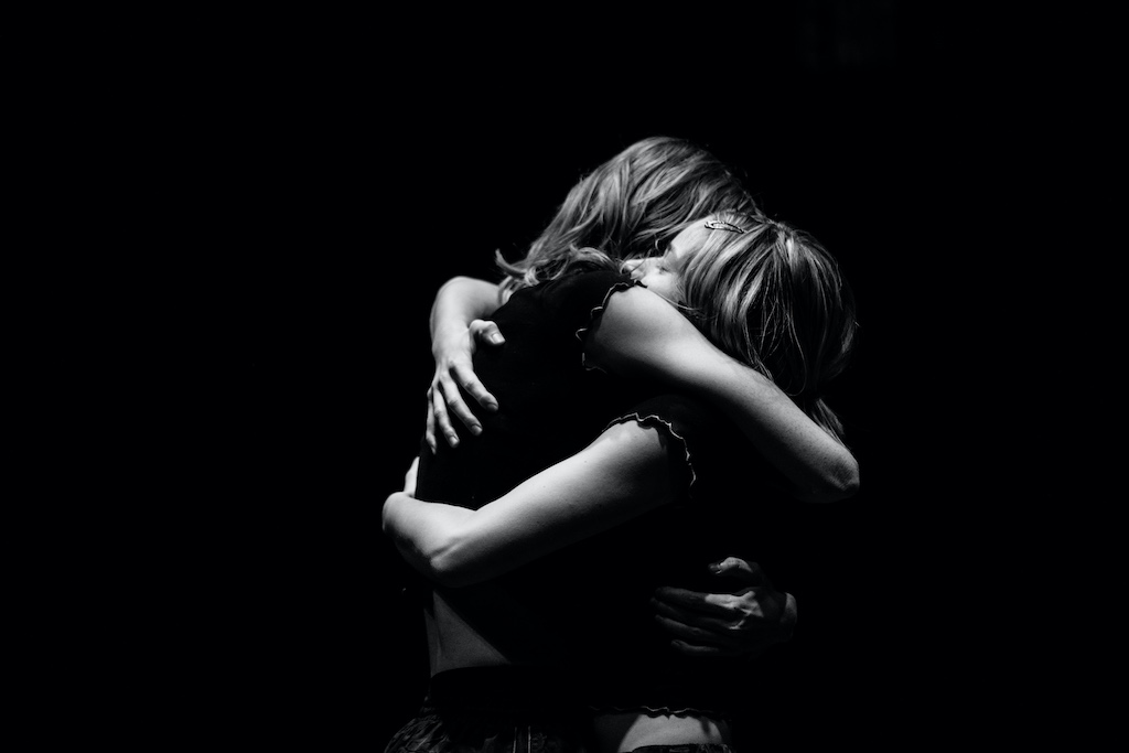 2 white cis-women sisters embrace each other. 