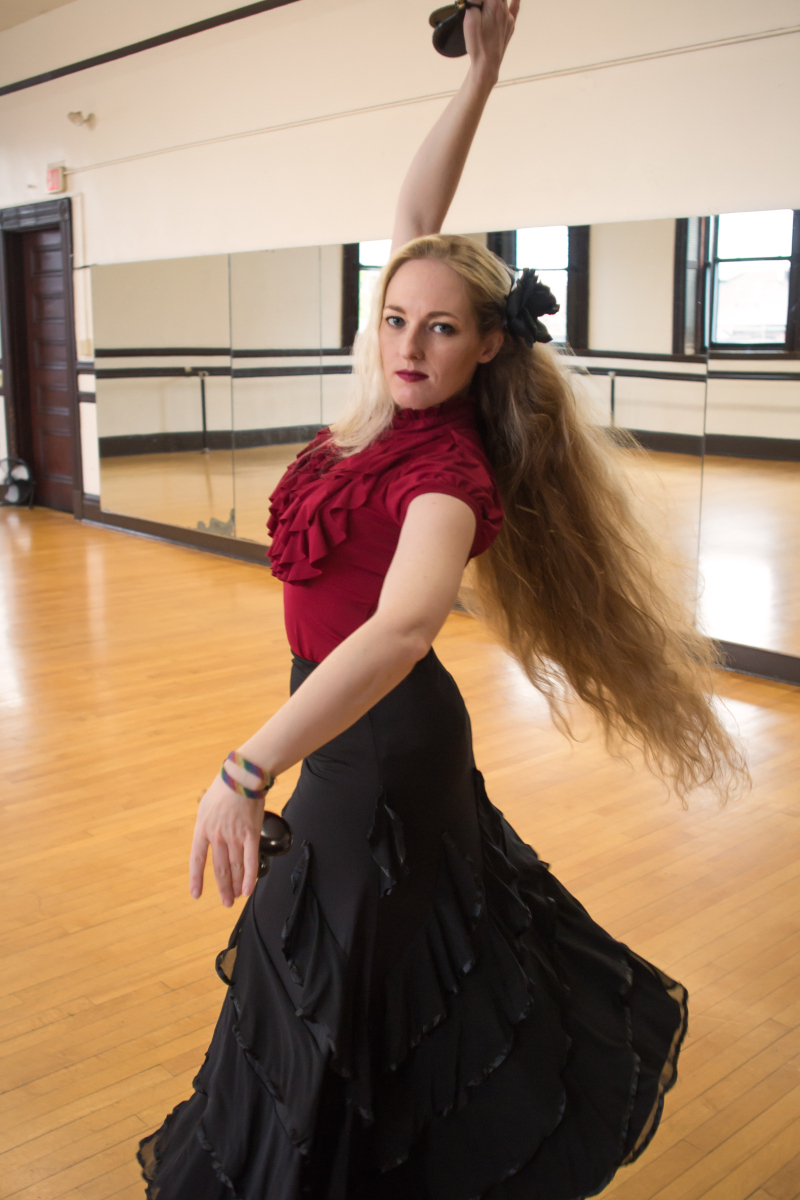 A woman with long red hair in flamenco garb