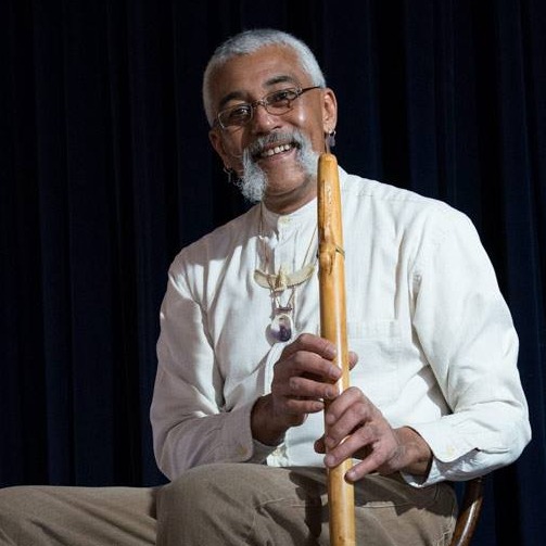Hawk smiling , holding one of his flutes