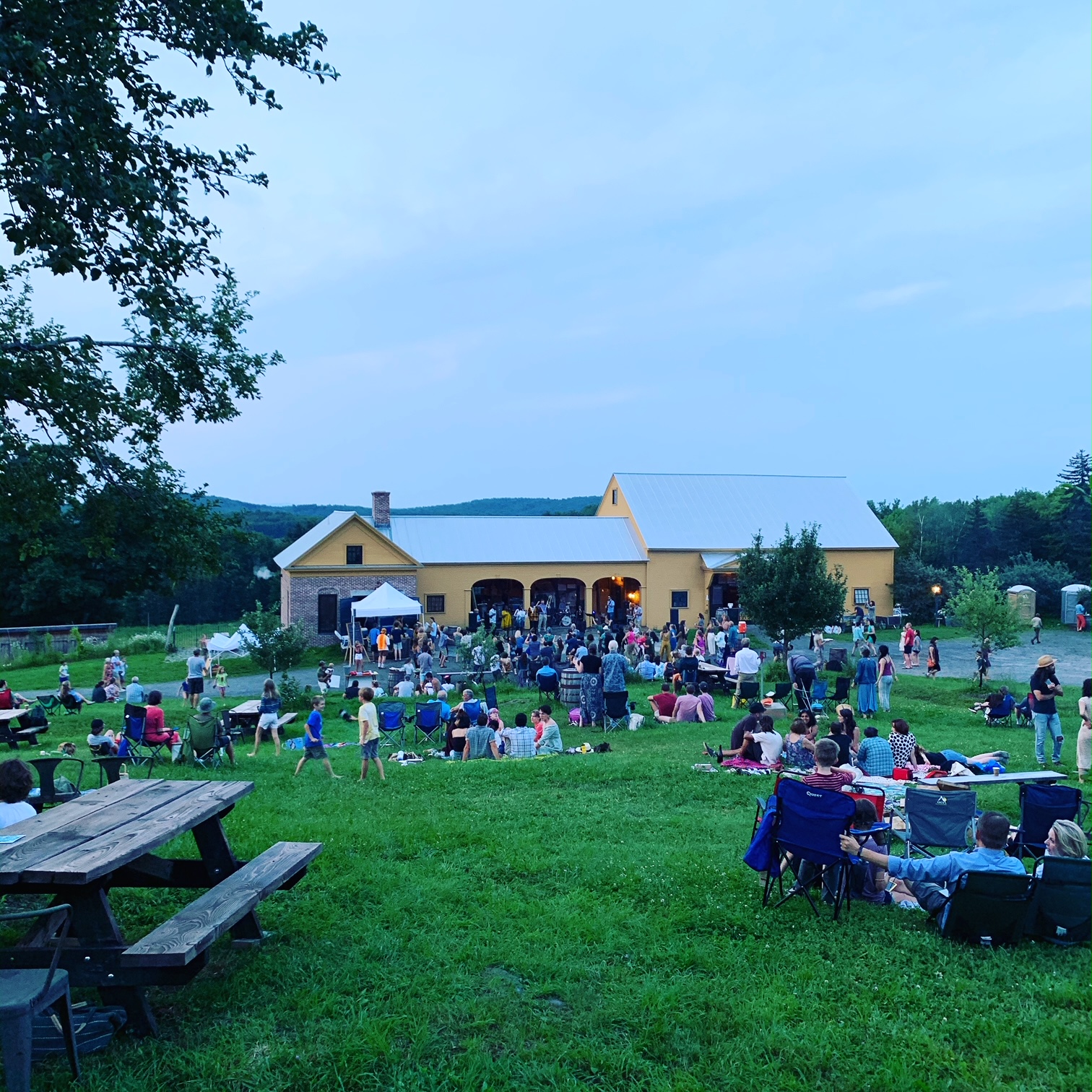 Outdoor Crowds at the Summer Music on the Farm Series at Dusk 