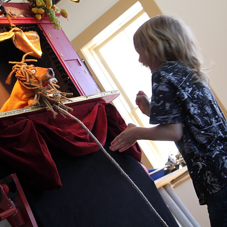 A lion surprises an audience volunteer during "The Perils of Mr. Punch"