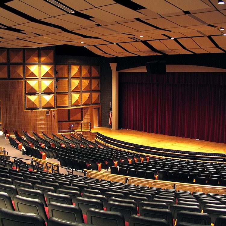 Theatre auditorium with black seats and red curtain