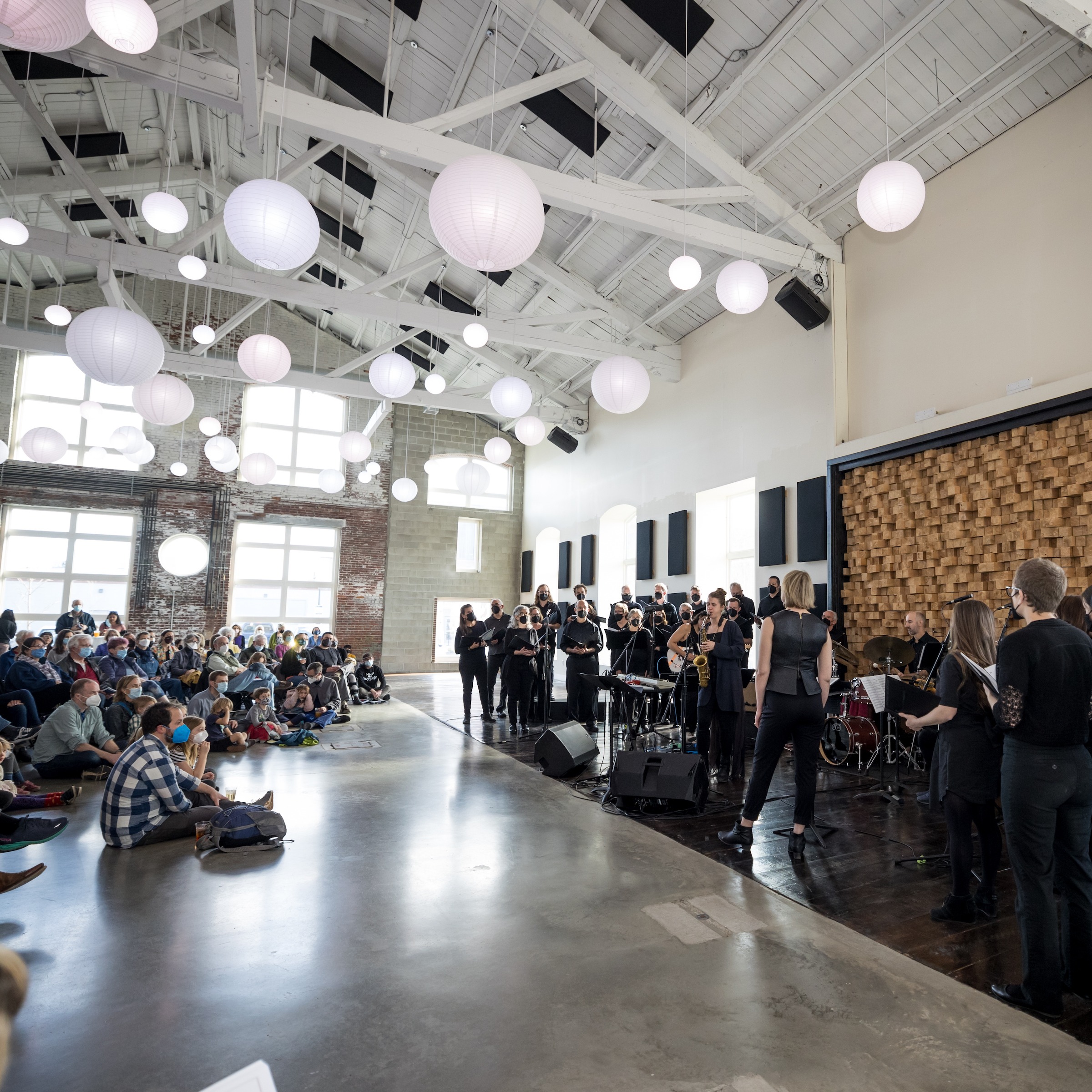 choir with jazz band performing in industrial space for audience