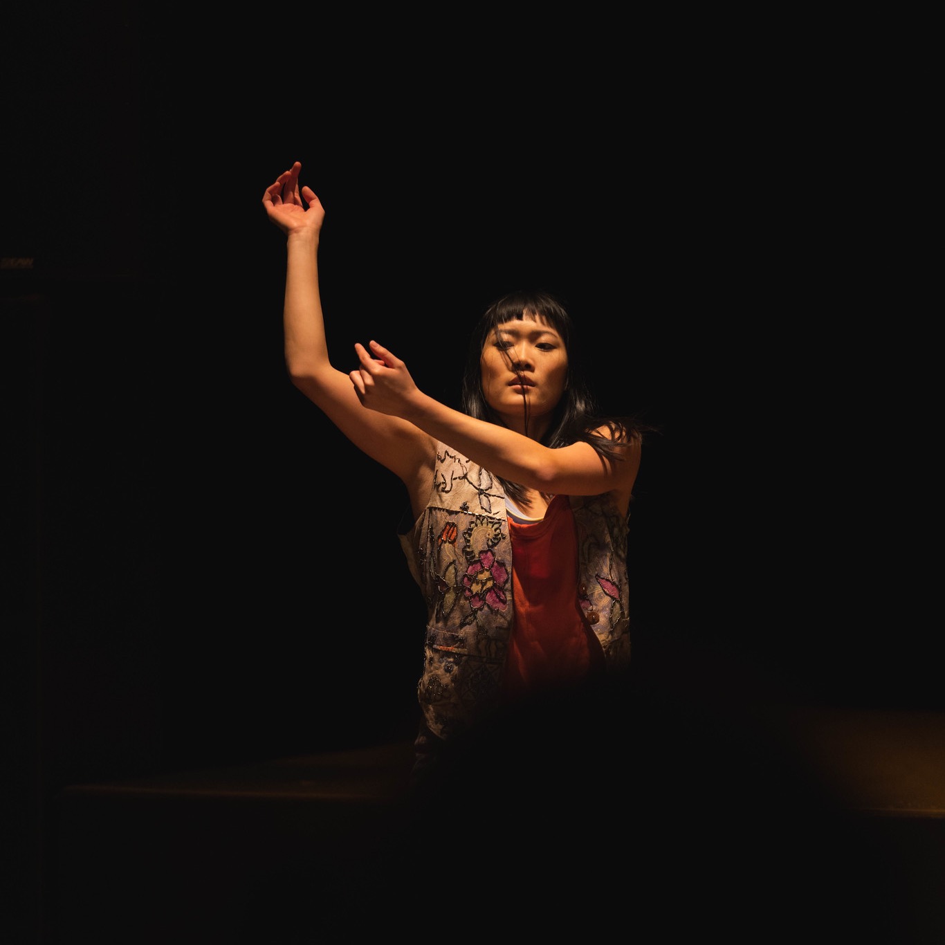 Woman extending both arms towards her right