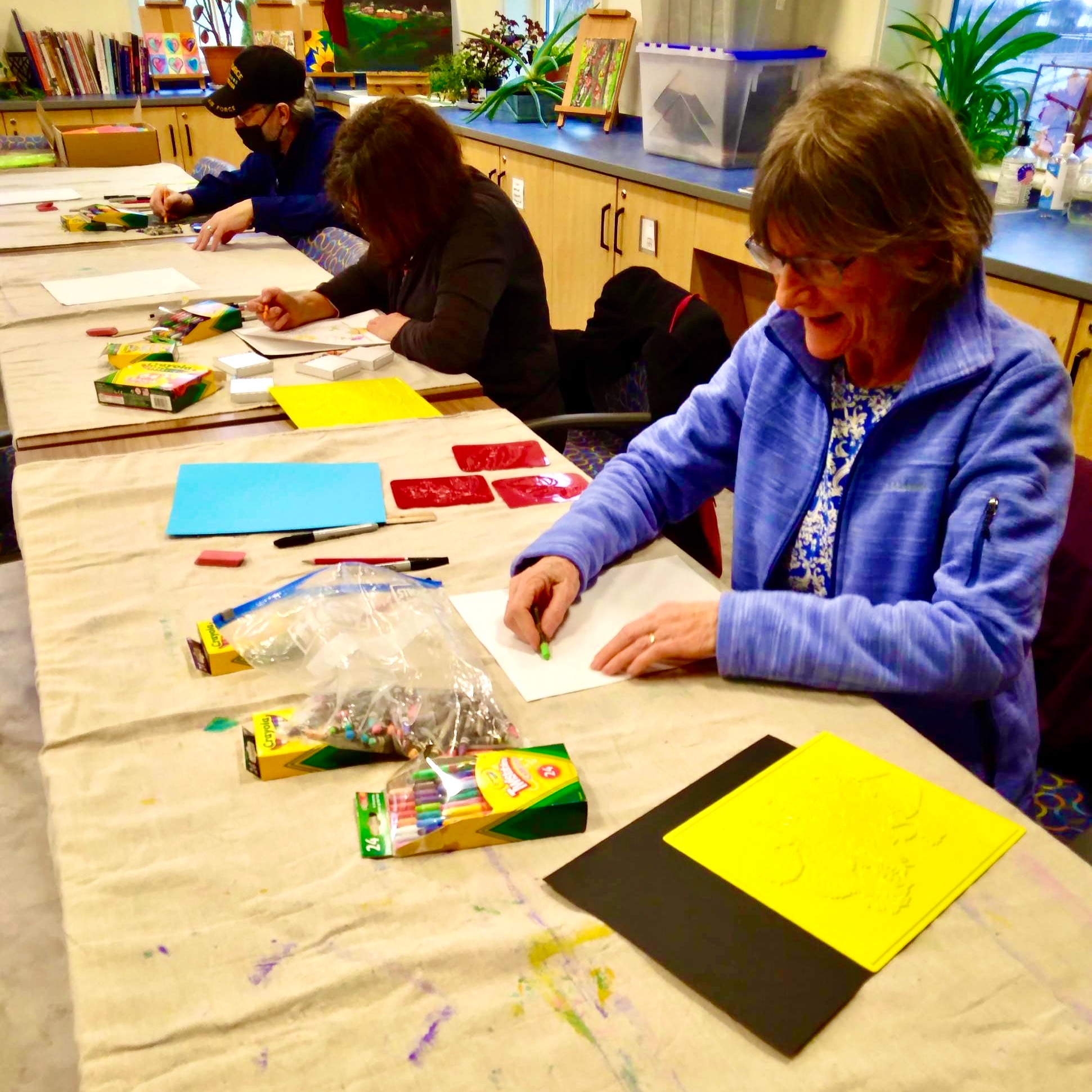 Participants using crayons to create artwork