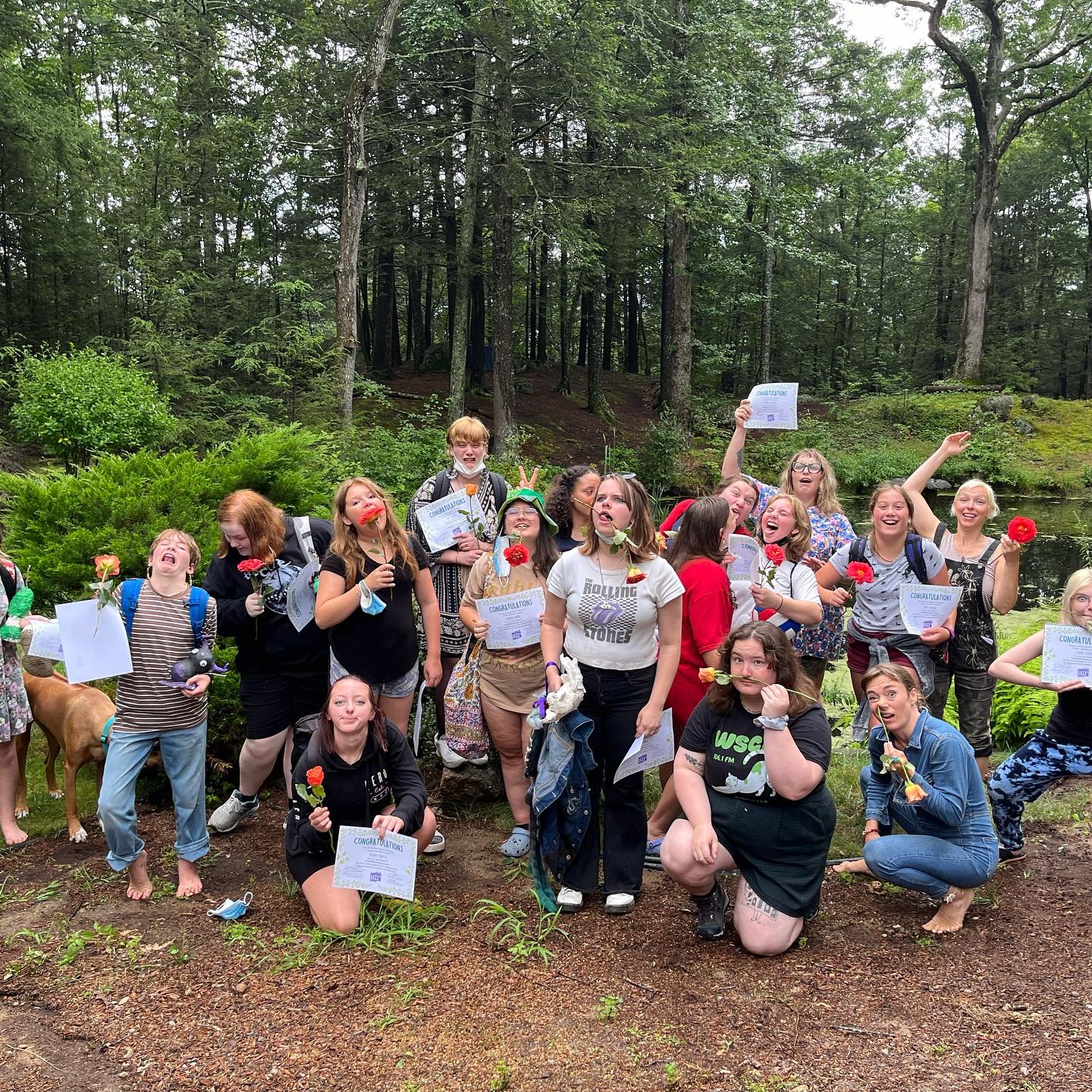 In the Summer of 2023, a gathering consisting of approximately 17 teenagers and staff members from AIR proudly display certificates and photographs outdoors, marking their successful completion of Storycamp.