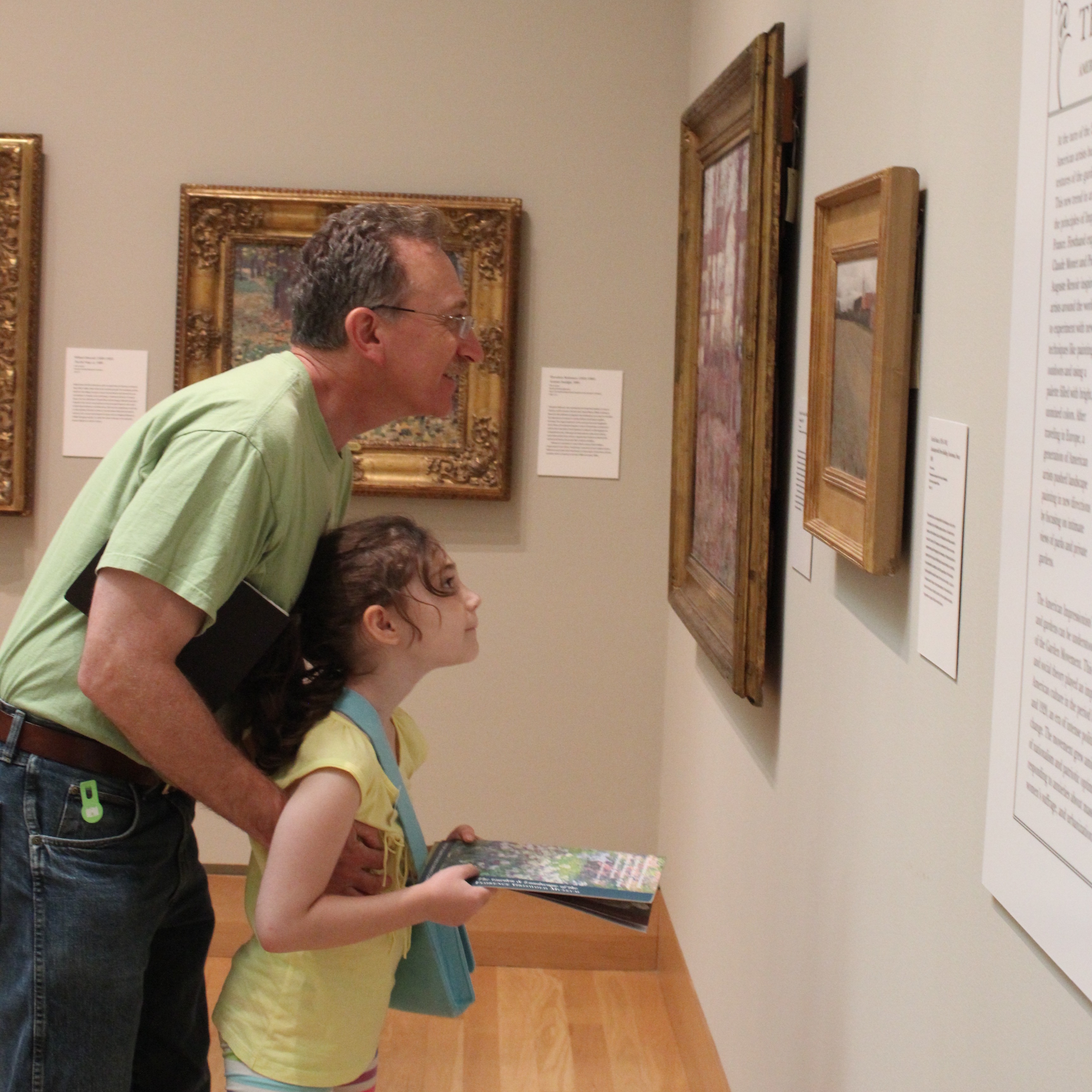 Father and daughter reading label together in exhibition