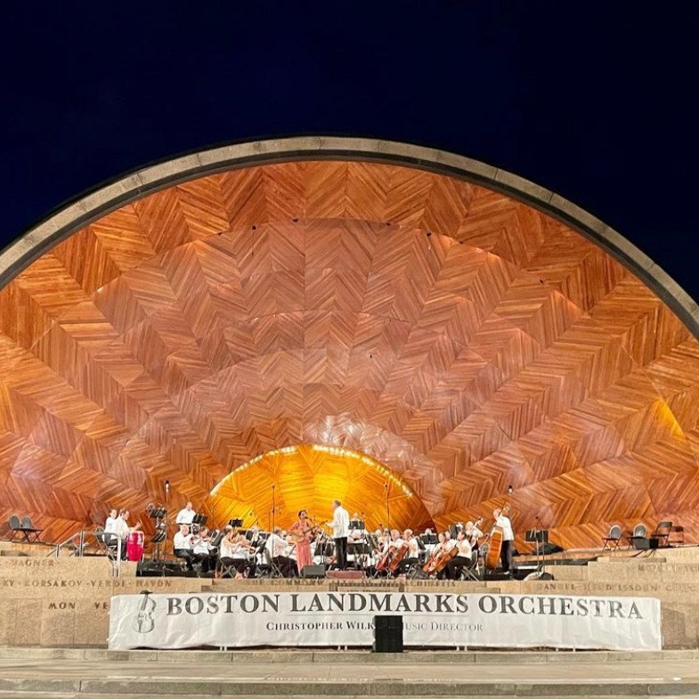 Image shows Fabiola Méndez alongside the Boston Ladmarks Orchestra performing at the Hatch Shell in Boston