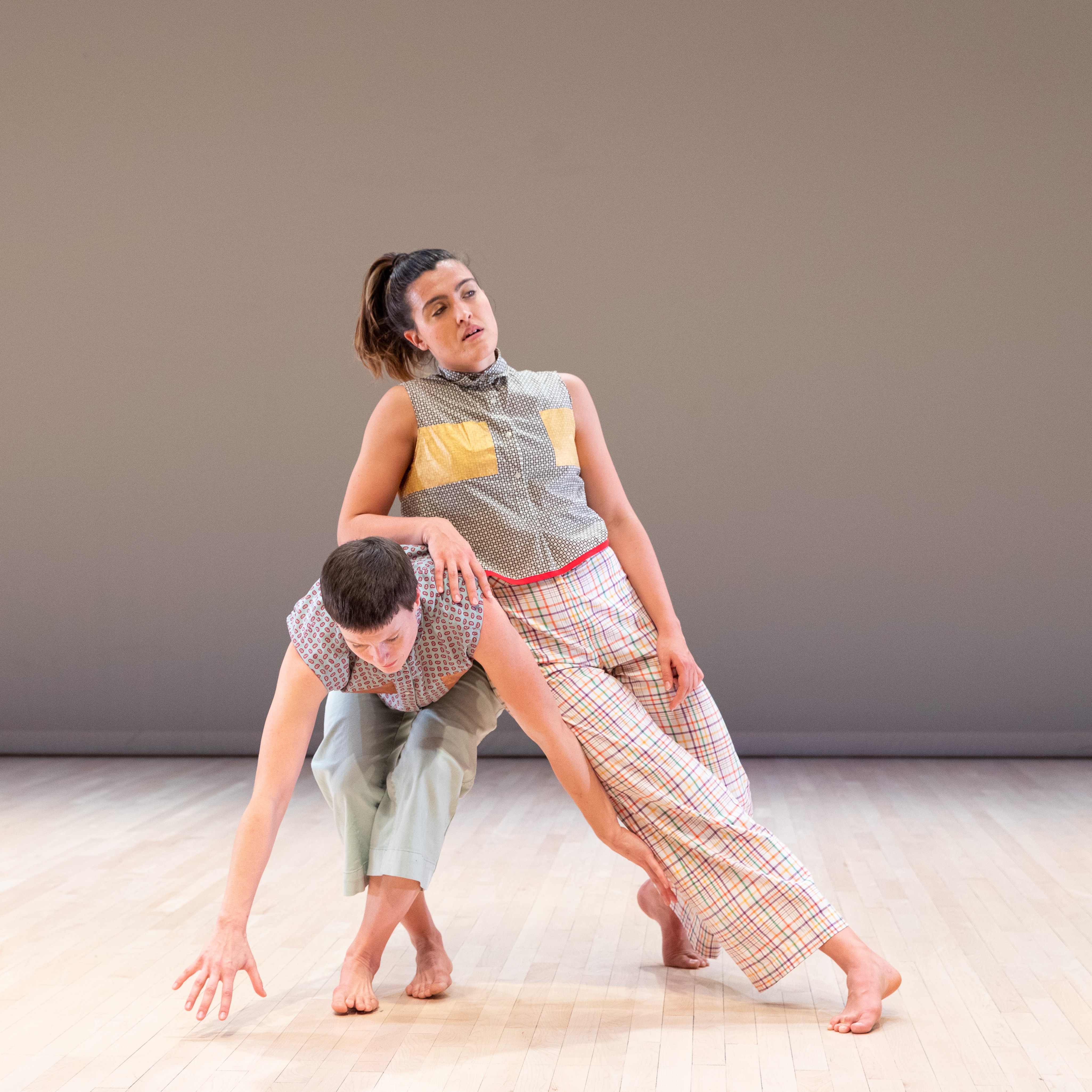 A dancer leaning casually on another who is falling
