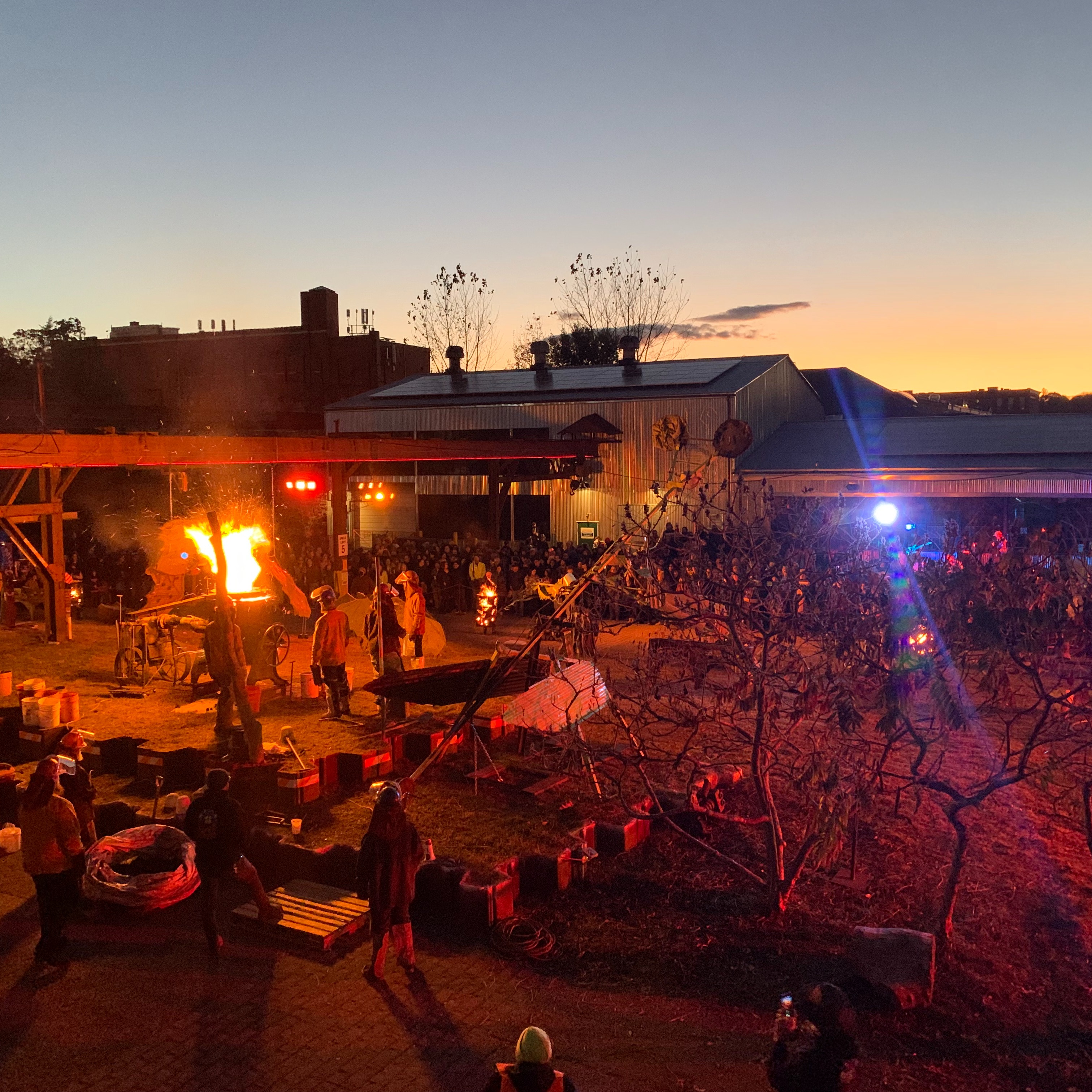 Elevated shot of The Steel Yard's campus at night, illuminated fires during their annual Iron Pour and Sims Ave Festival.