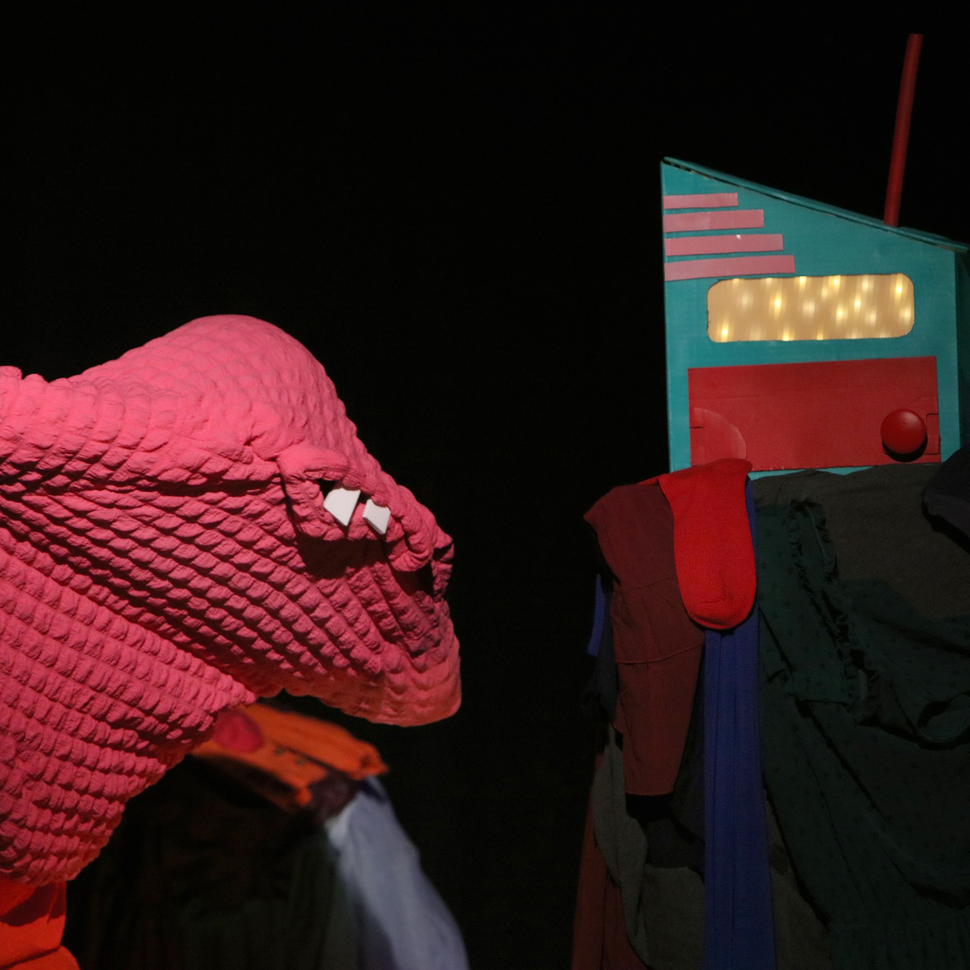 a pink puppet with white teeth eyes its next meal:  a sock!