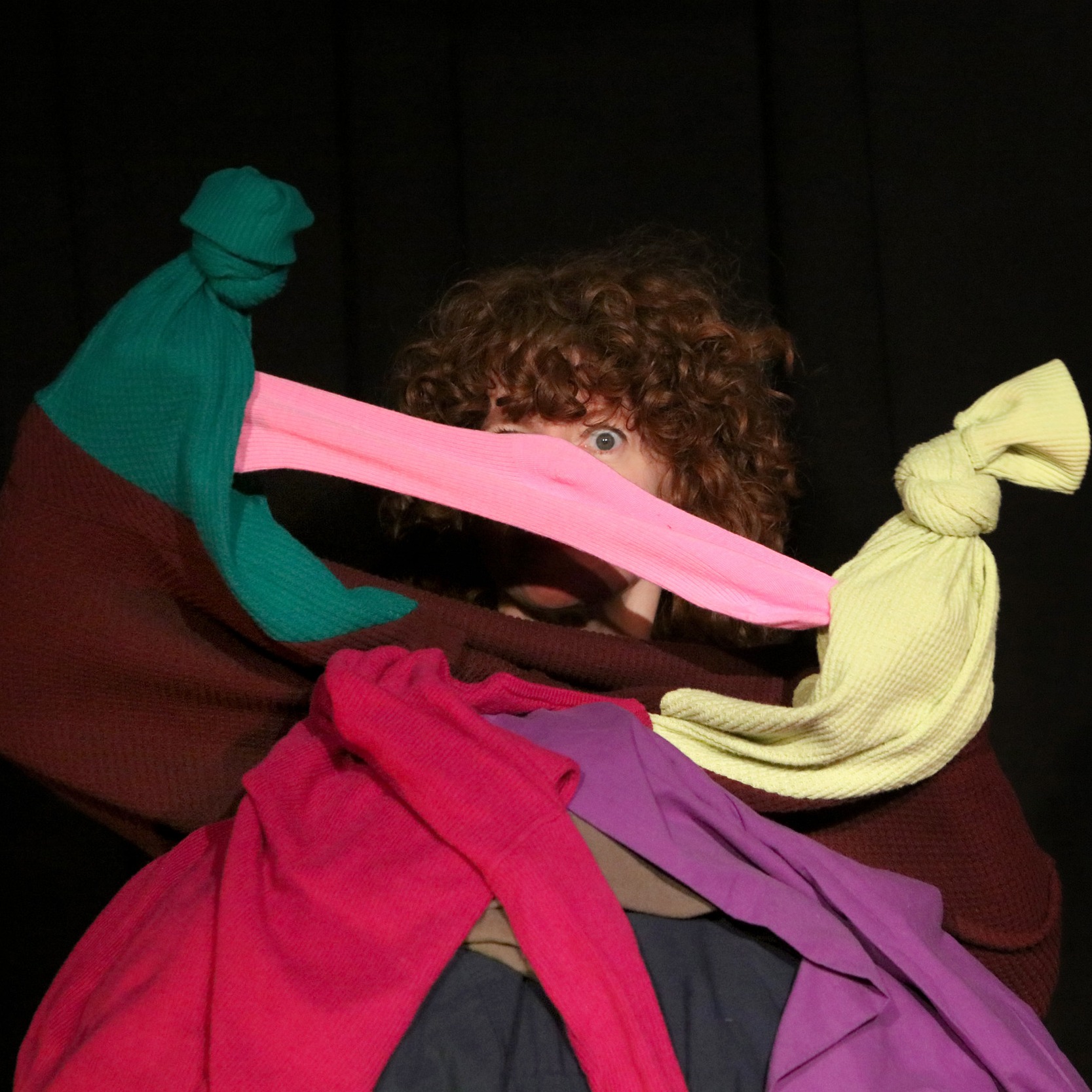 Bonnie peeks out between two hand puppets fighting over a sock
