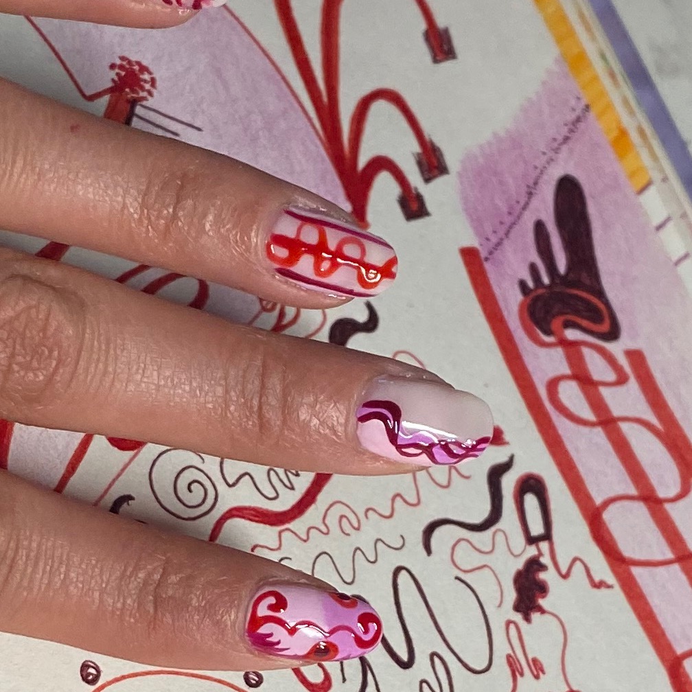 Art manicured hand over the page of a notebook, each nail matching a part of the page.