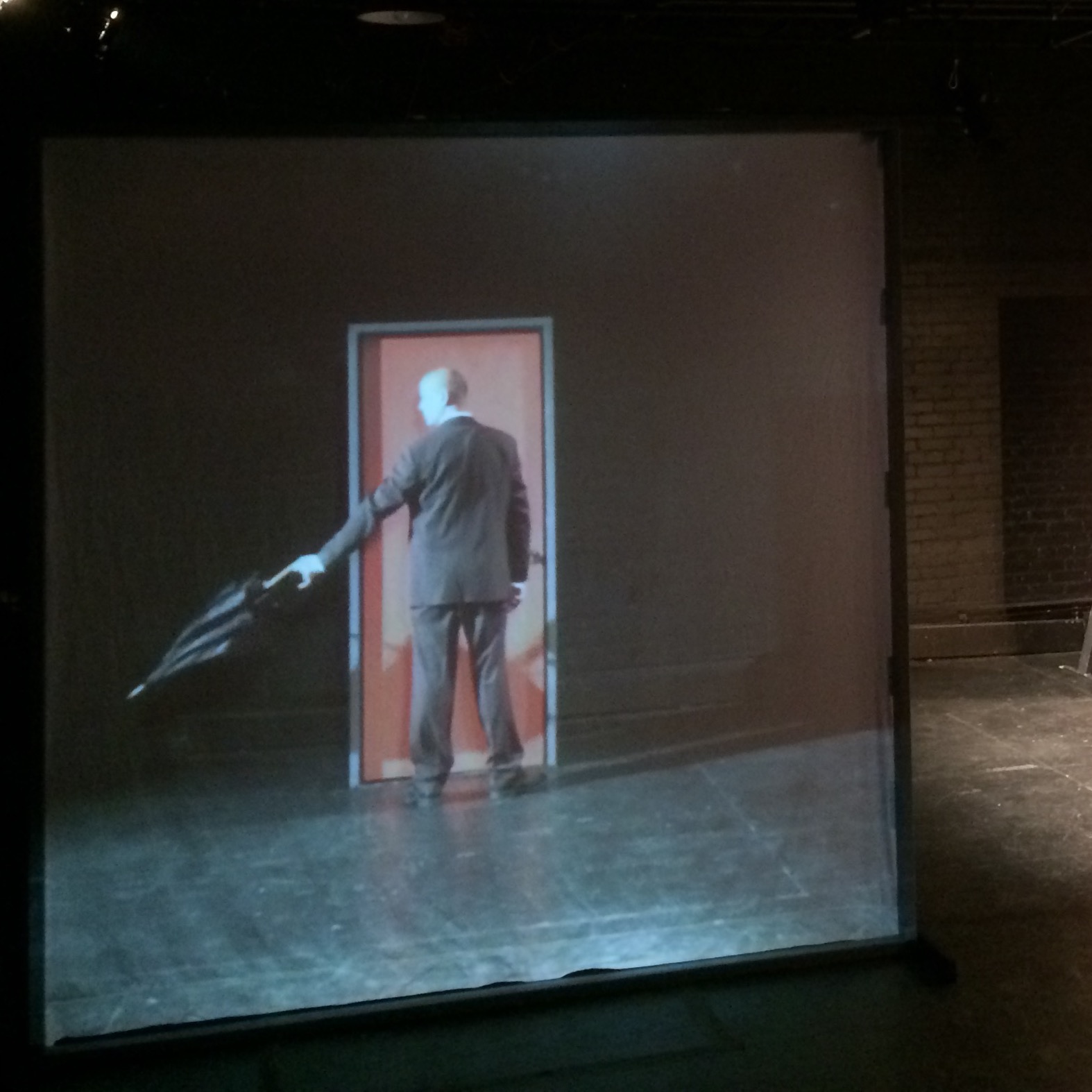 video of man in suit holding umbrella in front of orange door