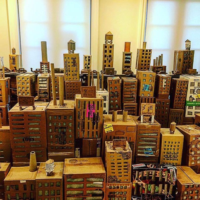 A cityscape made out of cardboard, in three rows