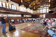 People in large room looking at artist