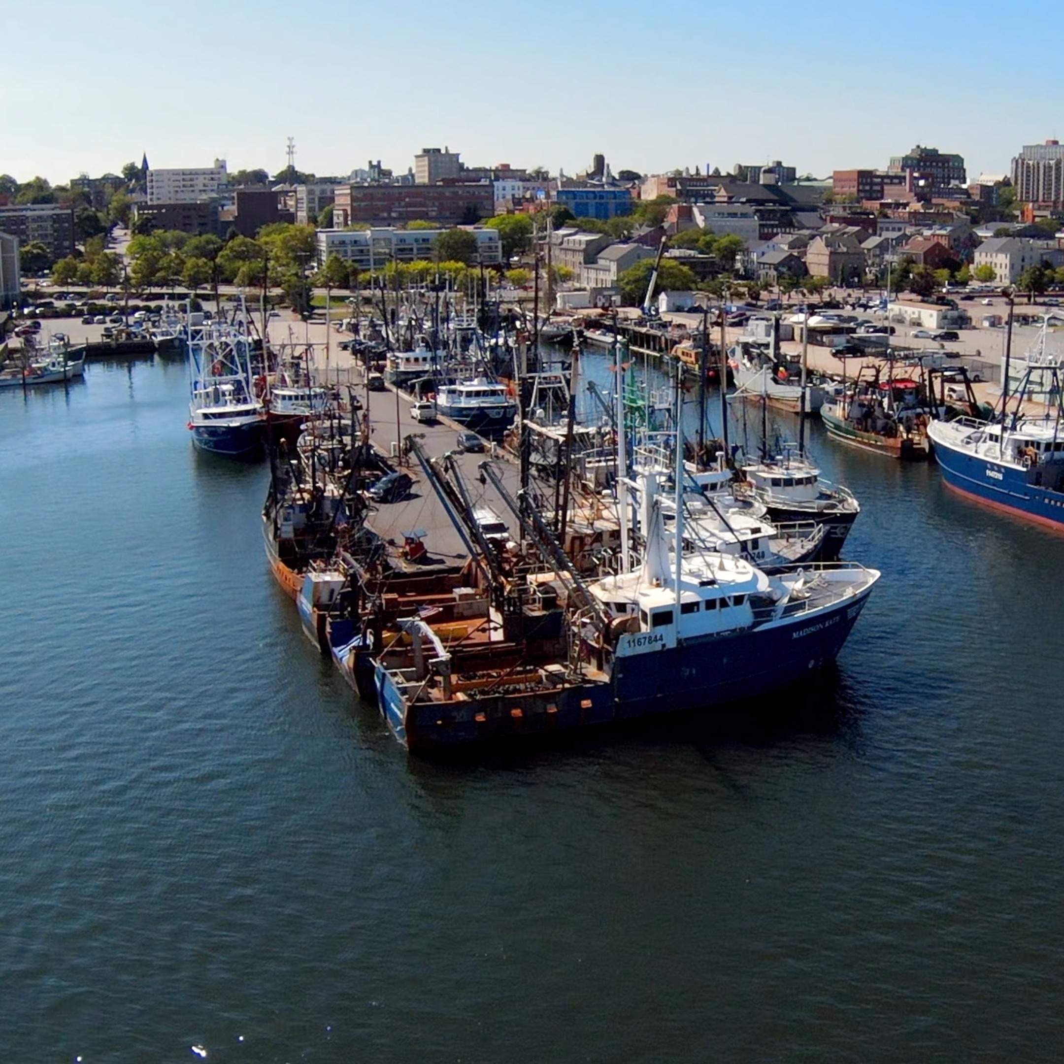 Drone photo facing Northwest that includes Port of New Bedford, several fishing vessles on the water 