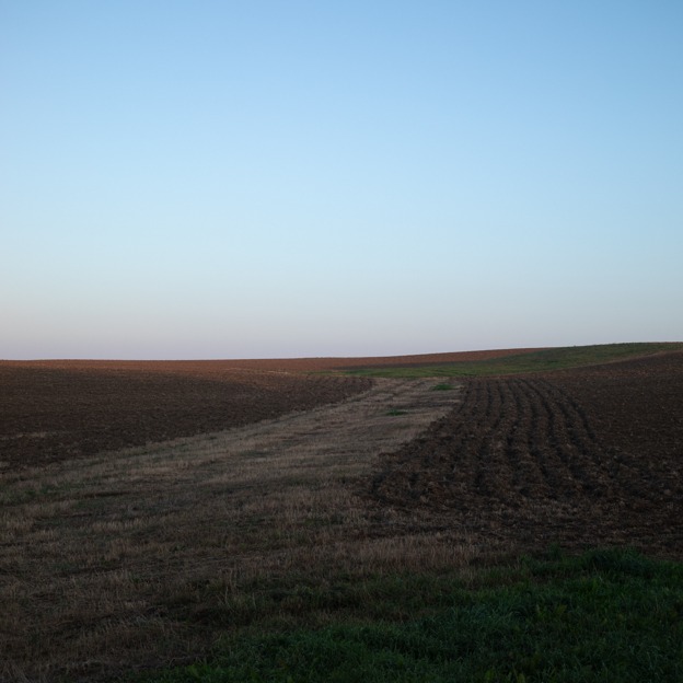 Photograph of a dark brown landscape with a blue sky