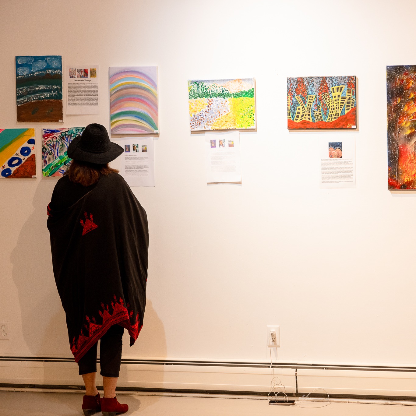 Gallery wall for an exhibit showing a visitor reading about the artists.