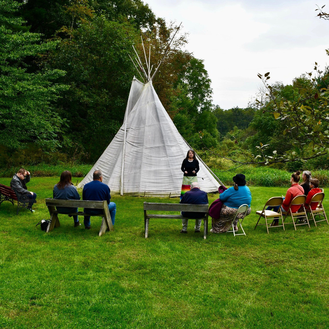 Storyteller in front of tipi
