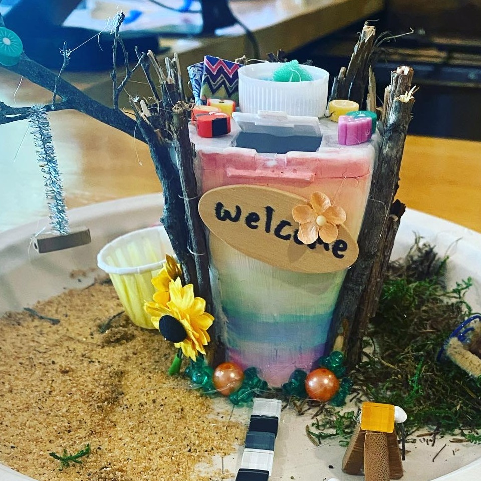 a homemade fairyhouse with a welcome sign