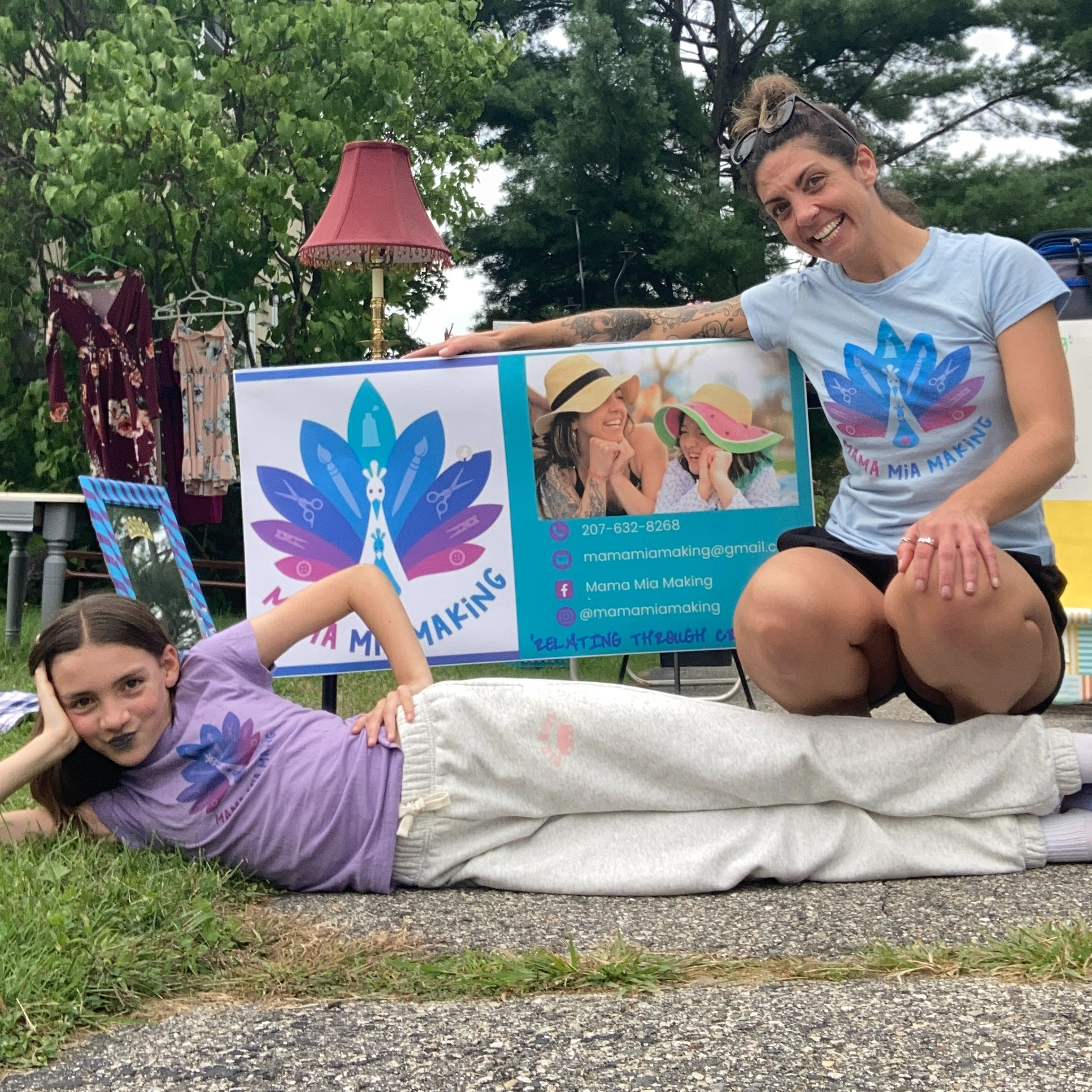 Mama and Mia posing with their banner and tshirts