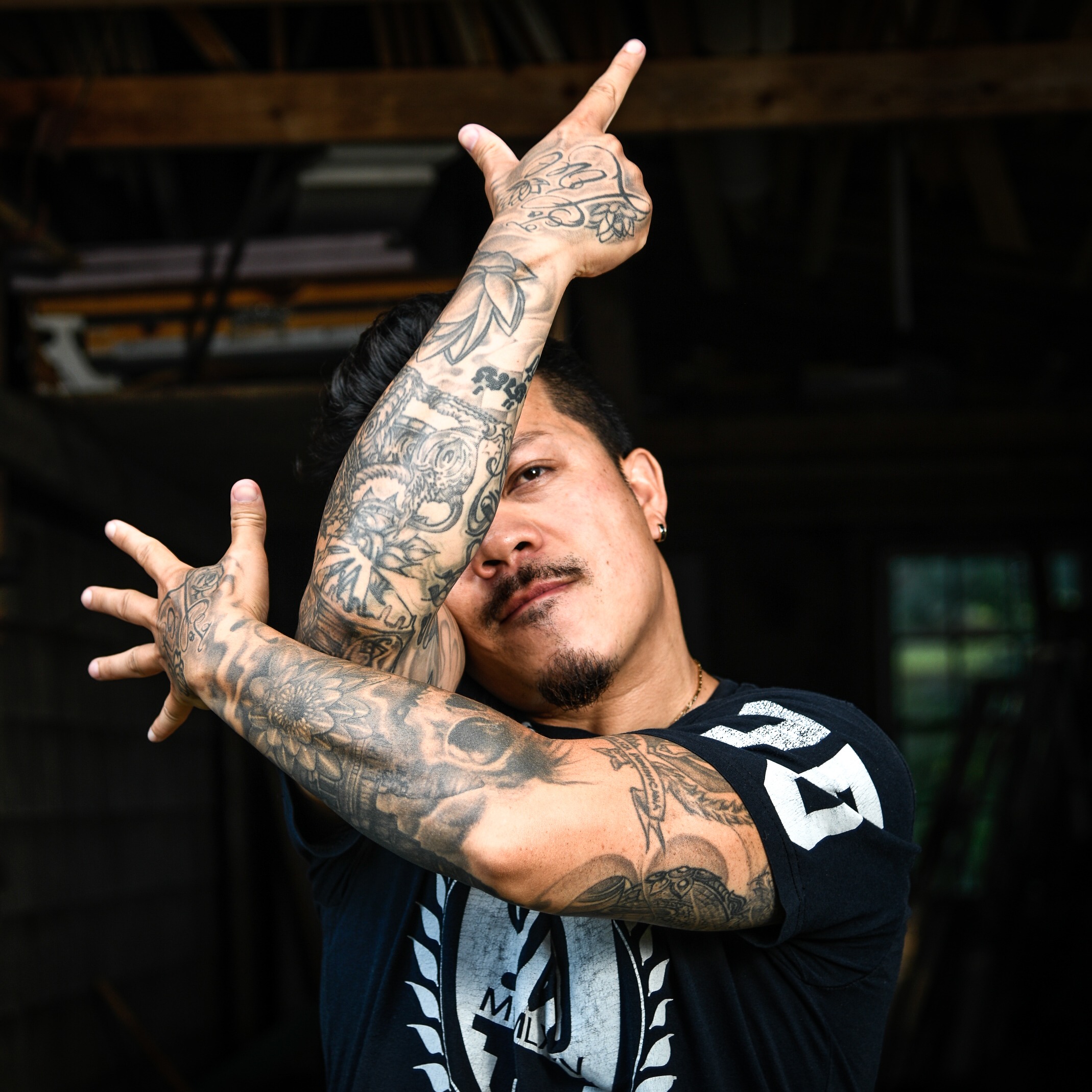 Cambodian man with tatttoos doing a dance pose