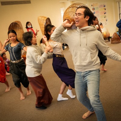 Angkor Dance Troupe's masters and instructors rehearsing a Khmer folk dance with young students.
